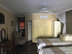 a hotel room with two beds and a ceiling fan at Gweta Lodge in Gweta