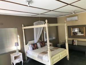 a bedroom with a canopy bed with a ceiling at Gweta Lodge in Gweta