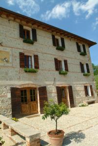 a large stone building with a tree in front of it at Le Fade in Susegana