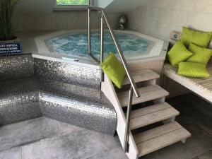 eine Whirlpool-Badewanne mit Treppe im Bad in der Unterkunft Hotel Imperium in Chełmża