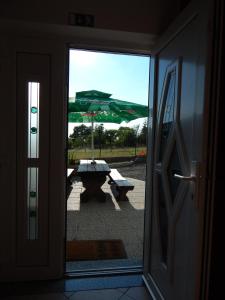 a view of a picnic table and an umbrella from a door at Hostel Ociski Raj in Kozina