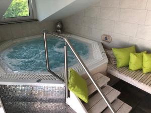a jacuzzi tub with green pillows in a room at Hotel Imperium in Chełmża