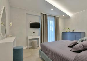 een slaapkamer met een bed en een televisie. bij Amnis suites in Santa Maria di Castellabate