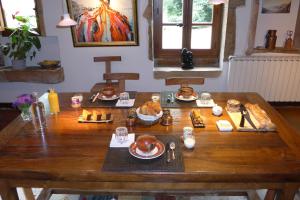 uma mesa de madeira com comida em cima em Le Lavoir de Meziat em Vinzelles