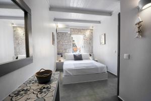 ein kleines Schlafzimmer mit einem Bett und einem Spiegel in der Unterkunft Alia Studios in Gaios