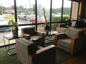uma sala de espera com cadeiras, mesas e janelas em Days Inn by Wyndham Fayetteville-South/I-95 Exit 49 em Fayetteville