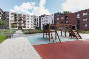a park with a playground with benches and buildings at Apartments Claro II by Renters in Krakow