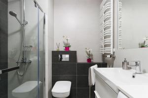 a bathroom with a shower and a toilet and a sink at Apartments Claro II by Renters in Krakow