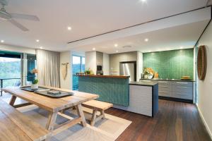 a kitchen and dining room with a wooden table at Grandview Retreat in Pullen Vale