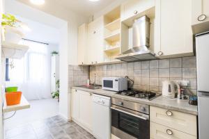 a kitchen with white cabinets and a stove top oven at Centre Apartment Old Tbilisi in Tbilisi City