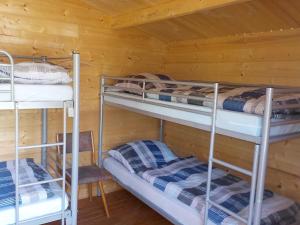 a room with three bunk beds in a cabin at Zehrermühle Campinghütte in Schönberg