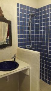 een blauwe betegelde badkamer met een wastafel en een douche bij BLAU in Masnou