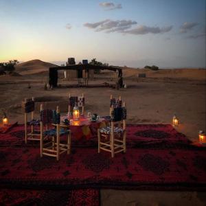 a dinner table in the middle of the desert at Bivouac Mélodie du désert in Mhamid