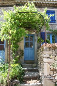 シャントメルル・レ・グリニャンにあるLa Salamandre Bleueの登山植物付きの石造りの家の青い扉