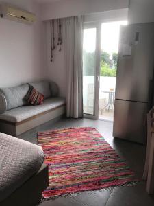 a living room with a couch and a rug at Kostas Studios in Faliraki