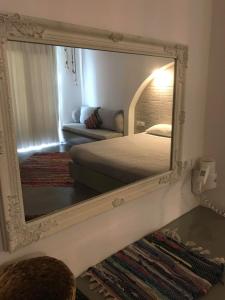 a mirror reflecting a bedroom with a bed and a couch at Kostas Studios in Faliraki