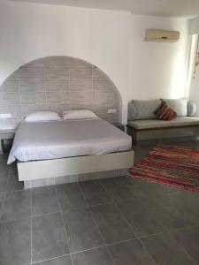a bedroom with a large bed and a couch at Kostas Studios in Faliraki