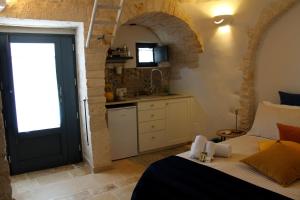 a bedroom with a bed and a kitchen with a window at Il Trullo di Mari' - Locazione turistica in Alberobello +44 photos