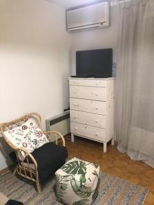 a room with a chair and a dresser with a television at Studio in the center of Saint-Jean-cap-Ferrat in Saint-Jean-Cap-Ferrat