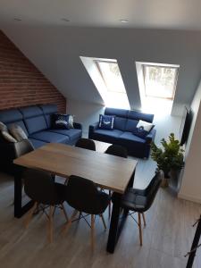 a living room with a table and a blue couch at Apartamenty Platinum 2 in Łukęcin