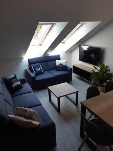 a living room with a blue couch and a tv at Apartamenty Platinum 2 in Łukęcin