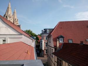 Blick auf die Dächer von Gebäuden und eine Kirche in der Unterkunft Ferienwohnung Linsenstrasse 13 in Mühlhausen