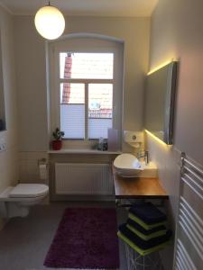 a bathroom with a toilet and a sink and a window at Ferienwohnung Linsenstrasse 13 in Mühlhausen