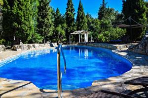 a large pool with blue water in a yard at Casas Rurales Los Algarrobales in El Gastor