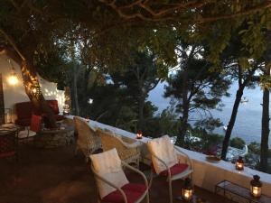 un patio avec des chaises et une vue sur l'océan dans l'établissement Villa Guya, à Capri