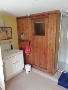 a bathroom with a sink and a wooden wall at Percy House in Wimborne Minster