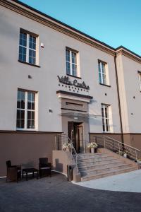 ein großes weißes Gebäude mit einer Treppe, die zur Tür führt in der Unterkunft Villa Centro in Oświęcim
