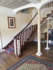 a living room with a staircase with a rug at Percy House in Wimborne Minster