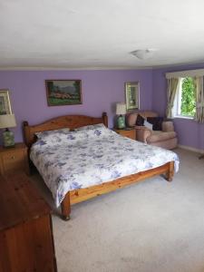a bedroom with a large wooden bed with purple walls at Percy House in Wimborne Minster