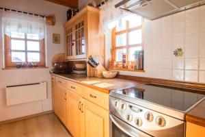 a kitchen with wooden cabinets and a stainless steel stove at Vila Idila in Lendava