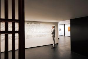 a man standing in front of a wall in a museum at The Peninsula Beijing in Beijing