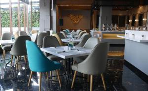 a row of tables and chairs in a restaurant at PRIME PARK Hotel & Convention Pekanbaru in Pekanbaru