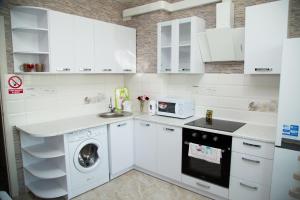 a kitchen with white cabinets and a dishwasher at New House Comfort Apartment in Odesa