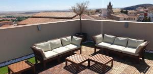 d'un balcon avec des canapés, une table et une vue. dans l'établissement Apartamentos AL-QAZERES LUXURY La Concepción, à Cáceres