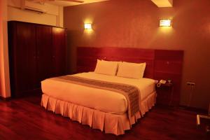 una camera da letto con un grande letto con lenzuola bianche di Unique Towers Luxury Boutique Suites a Colombo