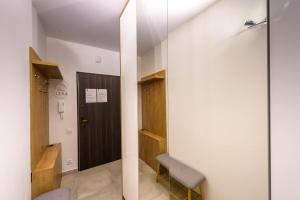 a room with a hallway with a door and a chair at Apartament Tajemnica Izerska - 5D Apartamenty in Świeradów-Zdrój +9 photos