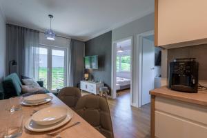 a kitchen and living room with a table and a living room at Apartament Tajemnica Izerska - 5D Apartamenty in Świeradów-Zdrój