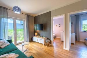 a living room with a couch and a table in a room at Apartament Tajemnica Izerska - 5D Apartamenty in Świeradów-Zdrój