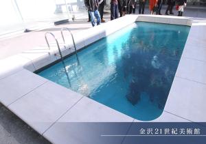 a swimming pool in a building with people standing around it at Hotel Trend Kanazawa Katamachi in Kanazawa