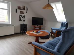 a living room with a table and chairs and a tv at Ferienwohnung Klütz - Unterkunft mit 2 Schlafzimmern und modernem Bad in Oeversee