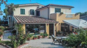 une maison avec une terrasse en face de celle-ci dans l'établissement B&b Giglio di Mare, à Cala Liberotto