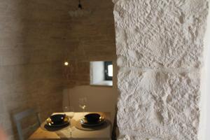 a dining table with two plates and glasses on it at Il Trullo di Mari' - Locazione turistica in Alberobello