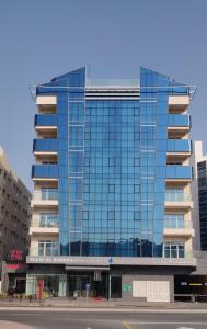 ドバイにあるTulip Al Barsha Hotel Apartmentの窓が多い高いガラス張り