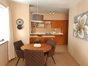 een keuken en eetkamer met een houten tafel en stoelen bij Sunset Apartment in Kaapstad