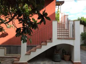 eine Treppe, die zu einem Gebäude mit einer roten Wand führt in der Unterkunft B&B Gente di Mare in Taormina