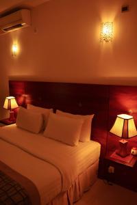 a bedroom with a large bed with two lamps at Unique Towers Luxury Boutique Suites in Colombo